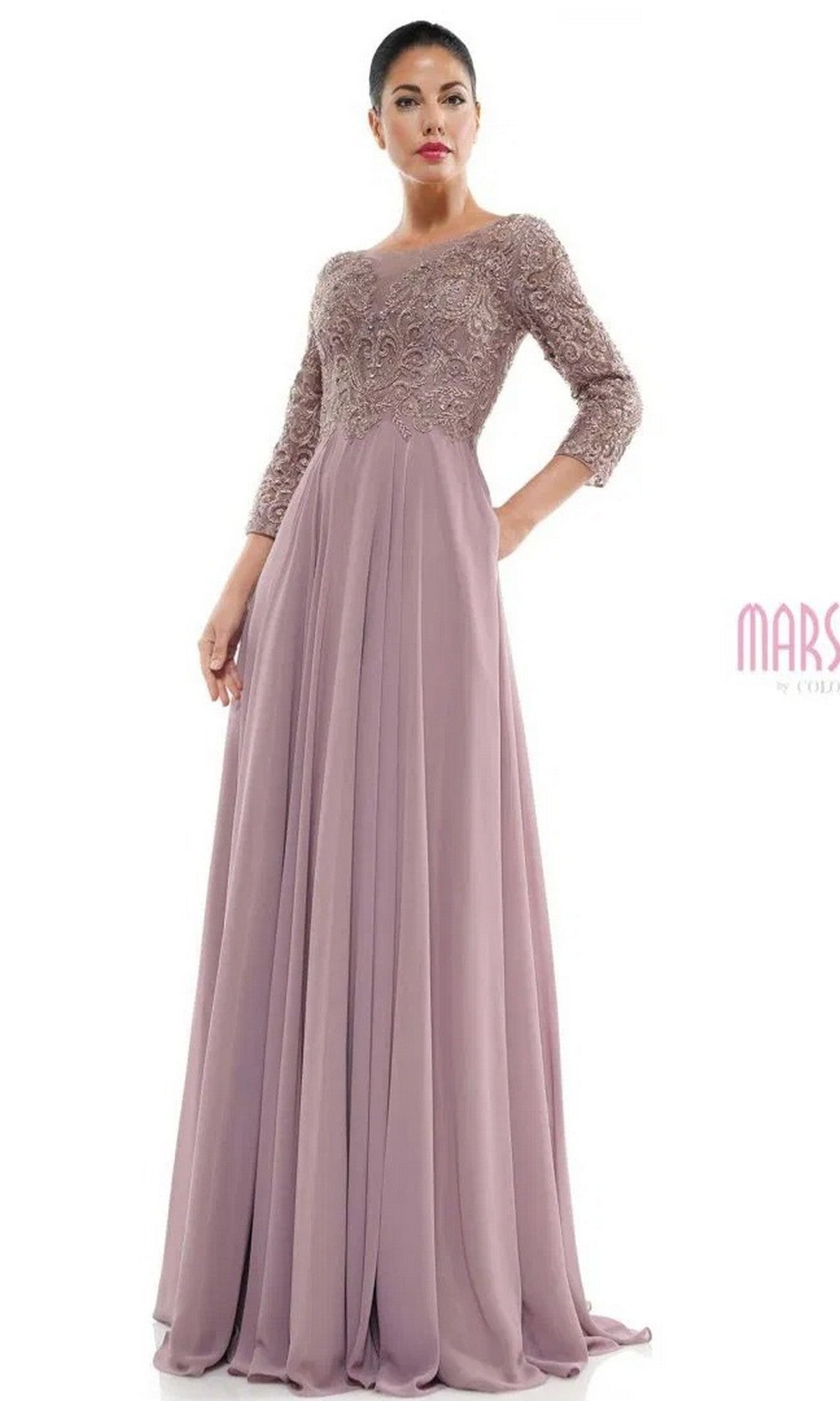 A woman models the Marsoni MV1052 long formal dress in mauve, featuring lace on the bodice, three-quarter sleeves, and a flowing chiffon A-line skirt, standing against a plain white background.